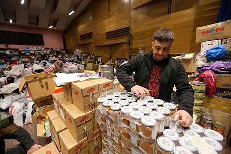 Vapaaehtoinen lajittelee humanitaarisen avun ruokatarvikkeita Brovaryssa Kiovan alueella 29. maaliskuuta.