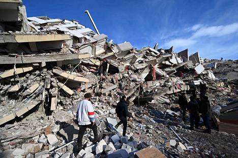 Paikallisia kuvattuna keskiviikkona romahtaneen rakennuksen raunioilla Kahramanmaraşin kaupungissa.