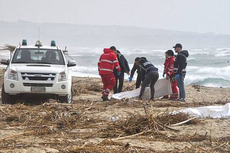 Pelastajat peittävät merestä löytynyttä ruumista Cutrossa helmikuun 26. päivä.