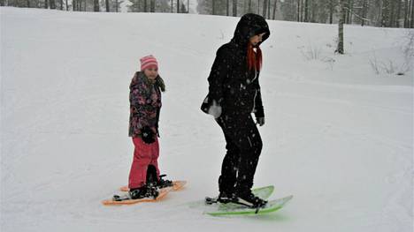 Aino Piskonen lähti reippaasti kokeilemaan lumipyrystä huolimatta lumikenkäilyä Janita Ylösen kanssa.