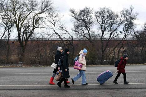 Ukrainalainen perhe kävelemässä kohti Ukrainan ja Puolan rajaa 28. helmikuuta 2022.