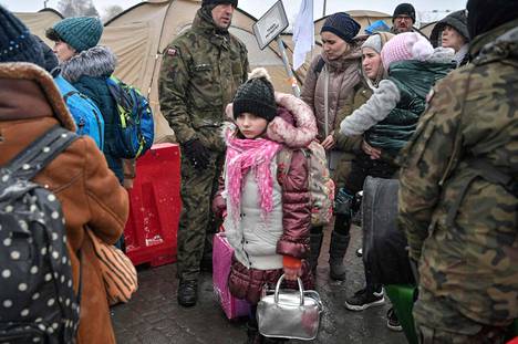Puolan armeijan sotilaat avustivat juuri maahan saapuneita Ukrainan pakolaisia 9. maaliskuuta Medykassa Puolassa.