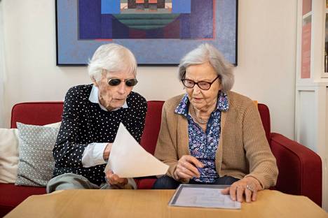 Gunda Johansson, 95 (vas.) ja Siiri Jaakkola, 94 tutkivat viikon kotiläksyjä. Gunda on joukon ainoa, jonka äidinkieli on ruotsi. Gunda Johansson, 95, och Siiri Jaakkola, 94, studerar veckans hemläxa. Gunda är den enda i gruppen som har svenska som modersmål. 