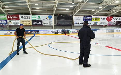 Liikuntapaikkamestari Erkki Virkalahti ja liikuntapaikkojen hoitaja Mikael Kangasniemi jäädyttivät jäähallin kaukalon pohjaa tiistaina