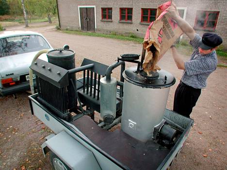 Vuonna 2000 otetussa kuvassa kärköläläinen Ismo Lehmusto tankkaa puukaasuautoaan puupilkkeellä. Kuvituskuva.