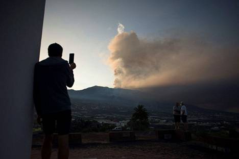 Mies kuvasi lauantaina puhelimella tulivuoresta nousevaa tuhkapilveä Los Llanos de Aridanessa La Palman saarella.
