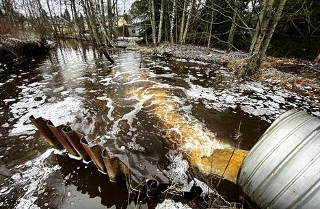Pitkäjärvenojan vesi on aiheuttanut jo pitkään ajoittaisia tulvahaittoja Tukkilahdenkadun kiinteistöille (taustalla). Padon pitäisi korjata tilanne, mutta samalla kärsii virtavesiluonto.