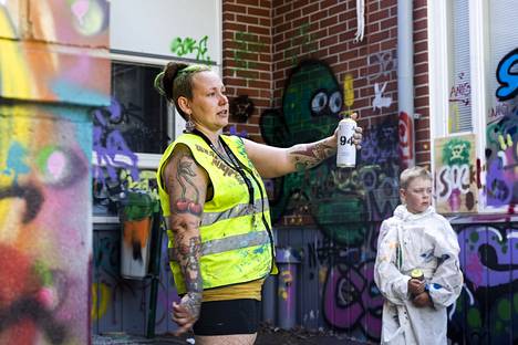 Suominen opasti graffitimaalauskurssille osallistuville nuorille, miten maalausvälinettä käytetään. Alueella on tarkoitus järjestää kesän aikana vielä useita erilaisia tapahtumia. 