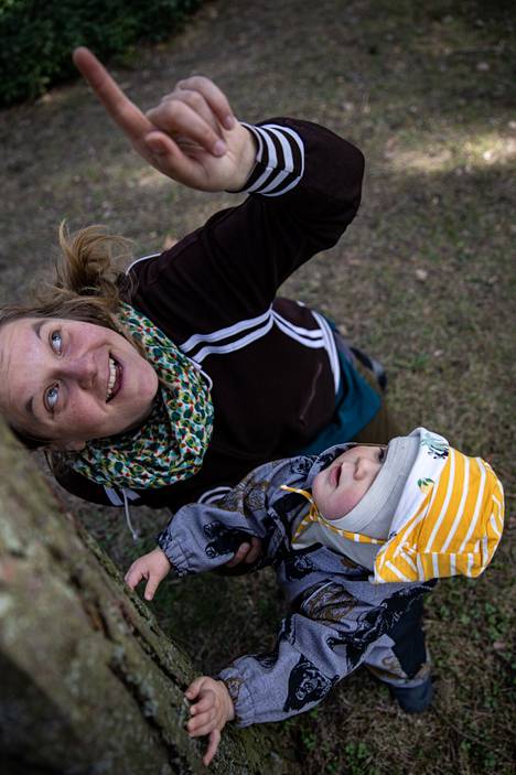 Alpi Mylly seisoo männynrunkoa vasten ja tapailee ensiaskeleita epätasaisessa maastossa. Anni Eskonen toimii vauvojen luontotapaamisten koollekutsujana.