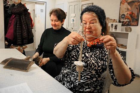 Riitta Saarijärvi esittelee yksinkertaista laitetta, jolla karstatusta villasta voi valmistaa lankaa. Laitteen nimi on värttinä. Karstausta harjoittelee Raija Kivimäki.