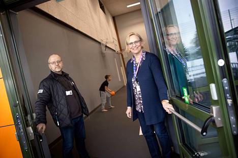 Rakennuttaja, insinööri Miika Pennanen ja rehtori Jaana Kujansuu Vähärauman uuden koulun liikuntasalin ovella. Liikuntasalin ovissa ei ole kahvoja vaan vahvan poistumistien vaatimukset täyttävä puomi, joka avautuu hätätilassa helposti.