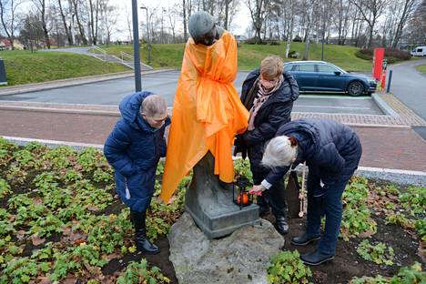 Marjatta-veistos sai oranssia ylleen Valkeakosken keskustassa tiistaina. Lisäksi kuvan Marjatta Ventonen, Marjatta Sievers ja Marketta Sarvikas sytyttivät kynttilän veistokselle.