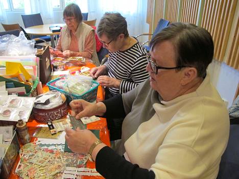 Liisa Hentunen, Kirsi Valavirta ja Sirkka Virtanen keskittyvät korttien tekemiseen. Naiset toivovat, että askartelukerhoon saataisiin myös uusia jäseniä.