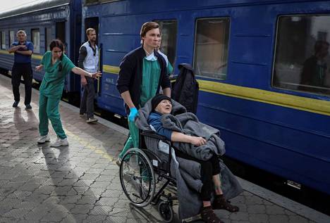 Hoitajat saattavat potilasta junaan, jota operoi Lääkärit ilman rajoja -järjestö ja Ukrainan terveysministeriö. Kuva on otettu Dniprossa 10. toukokuuta.