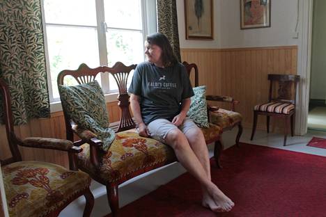 Kiikan aseman irtaimiston myyntitapahtumassa on useita sohvia on tarjolla. Sari Laurila istuu yhdellä niistä.
