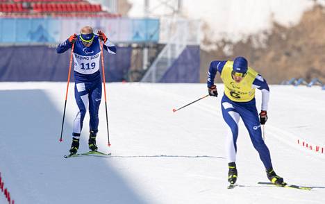 Suomen Inkki Inola hiihti sijalle 13 paralympialaisten näkövammaisten hiihtäjien miesten vapaan tyylin sprintissä, taustalla opashiihtäjä Jari Huhta.