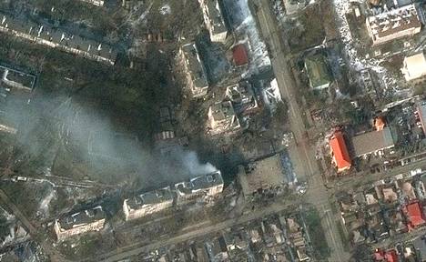 Satelliittikuva näyttää palavia kerrostaloja Mariupolin kaupungin läntisessä osassa 12. maaliskuuta.