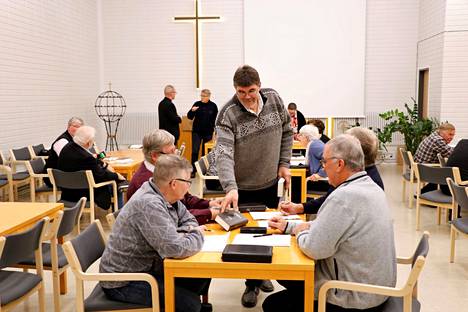 Erkki Lahtinen jakoi virsikirjoja, kun Kokemäen varsin miehinen kirkkovaltuusto käsitteli seurakuntakeskuksen lisätyölaskua kiireellisenä asiana lokakuussa 2021.