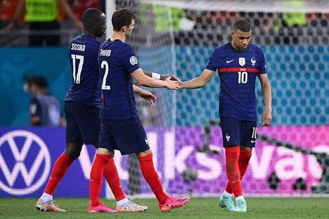 Ranskan maajoukkueen joukkuetoverit lohduttavat tähtipelaaja Kylian Mbappea (oik.) epäonnistuneen rangaistuspotkun jälkeen ottelussa Sveitsiä vastaan. Ranska hävisi maanantai-iltana Sveitsille jatkoajalla.