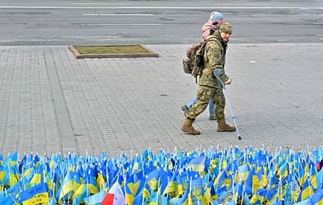 Haavoittunut ukrainalainen sotilas ohitti Kiovassa 22. helmikuuta sodassa kuolleiden muistoksi laitettujen Ukrainan lippujen meren. Jokainen lippu edustaa sodassa kuollutta sotilasta.