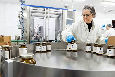 Tuotantotyöntekijä Maija Lehto pakkaa d-vitamiinipurkkeja laatikoihin. Tuotantolinjalta valmistuu kahdeksan 120 kappaleen purkkia minuutissa. 