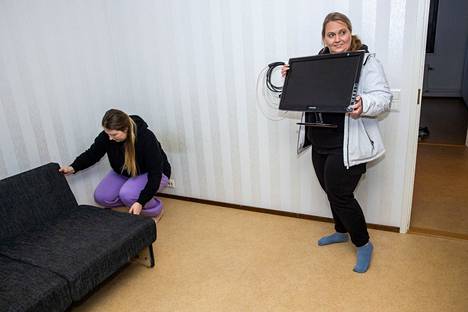 Saija Roininen (oik.) kantoi lahjoituksena saatua näyttöä, jota voi käyttää esimerkiksi televisiona. Kateryna Ištšenko asetteli sohvaa paikalleen seinän viereen.