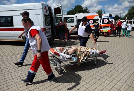 Punaisen Ristin ja Lääkärit ilman rajoja -järjestön työntekijät evakuoivat vanhuksia läheltä sodankäynnin rintamalinjaa Pokrovskissa, Donetskin alueella 18. heinäkuuta.