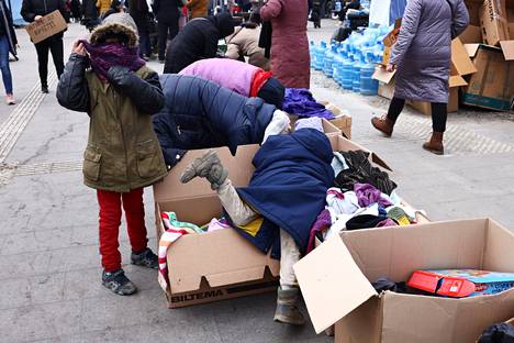Sotaa paenneet lapset kokeilivat pakolaisille lahjoitettuja vaatteita Lvivin rautatieasemalla Ukrainassa.