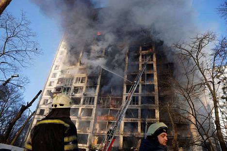 Pelastajat sammuttavat kerrostalopaloa, joka syttyi pommituksen seurauksena Kiovassa 15. maaliskuuta.