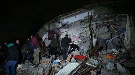 Ihmiset tutkivat sortuneen rakennuksen jäännöksiä Turkin Diyarbakirissa maanantaiaamuna.