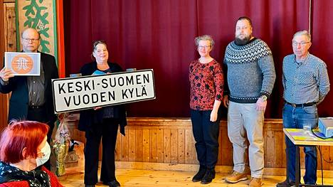 Kari Moisio ja Minna Hietala vastaanottivat Vuoden kylä -kyltinReena Laukkanen-Abbeylta, Ville Erkkilältä ja Jaakko Lindströmiltä.