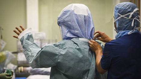 Hoitajat pukivat kirurgille suojavaatteet leikkaussalissa Kainuun keskussairaalassa Kajaanissa 8. heinäkuuta 2020.