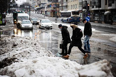 Jalankulkijat ja pyöräilijät liikkuivat päättyvänä talvena Tampereella monin paikoin vaikeissa olosuhteissa. Valokuva on otettu Satakunnankadun ja Kuninkaankadun risteyksestä 14. helmikuuta 2022.