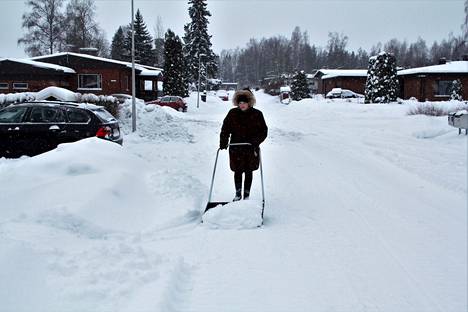 Reetta Ylevä lykkäsi tiistaina aamupäivällä lunta Juhannusvuoressa. "Onneksi tämä on kevyttä, mutta loppuisi tuo lumisade jo", hän sanoo. Lumikolat olivat toisillakin ahkerassa käytössä samalla kadulla.