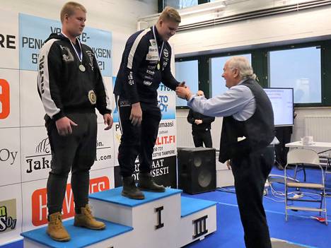 Mikael Salomäki nosti 18-vuotiaiden 120+ kiloisten sarjassa uuden Suomen ennätyksen. Kuvassa Salomäkeä palkitsemassa voimanostokisojen kuuluttajalegenda Heikki Orasmaa. 