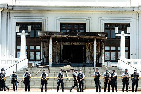 Poliisit seisovat tulipalossa vaurioituneen entisen parlamenttitalon edessä Australian Canberrassa.