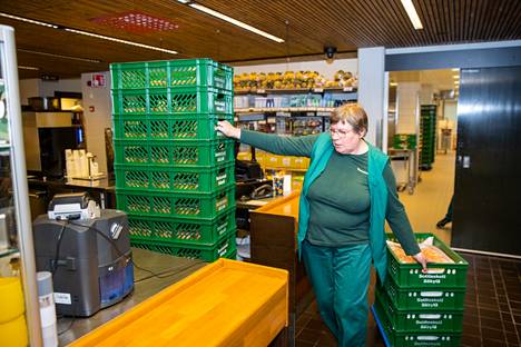 Sotilaskotityöntekijä Tarja Nieminen kuljettaa munkkeja myyntiin. Laatikoiden määrä kertoo olennaisen.