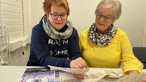 Rauman Työväen Naiskuoron Hanna-Leena Grönroos ja puheenjohtaja Anitta Heikkinen tutkivat vanhoja lehtileikkeitä. Molemmat kuuluvat juhlaviikonlopun järjestelytoimikuntaan. 
