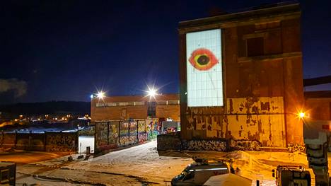 Arvo Yli-Kerttulan nelivuotiaana maalaama Musta aukko -teos heijastetaan aurinkopaneeleille Hiedanrannassa. Taideteos on nähtävillä Keittämö-tehdasrakennuksen seinällä pimeän aikaan.