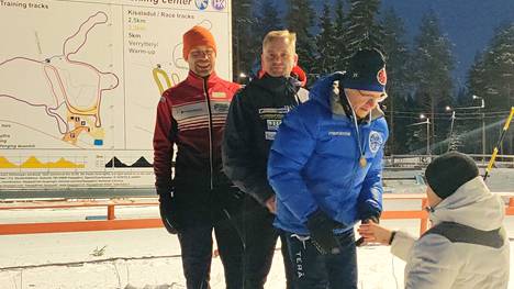 Kisailijoiden kultaa hiihtänyt viestikolmikko palkintokorokkeella Juha Koskinen, Timo Salminen ja Matti Aalto. 