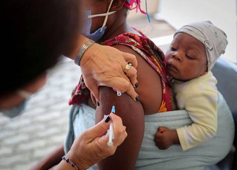 Terveydenhuollon työntekijä rokotti naisen Etelä-Afrikan Johannesburgissa 4. joulukuuta.