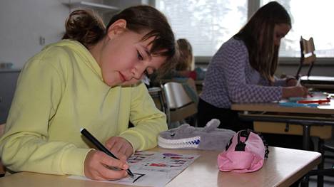 Sorrilan koulun viidesluokkalainen Ella Uschanoff teki viimeisellä viikolla jouluaiheista sarjakuvaa. Taustalla Senja Virkki.
