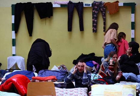 Ukrainalaiset pakolaiset lepäsivät väliaikaisiksi majoitustiloiksi muutetun koulun urheiluhallissa Przemyslissä, Puolassa tiistaina.