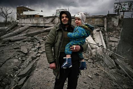 Mies kantoi lastaan, kun he pakenivat Irpinistä. Irpinin kaupunki sijaitsee lähellä Ukrainan pääkaupunkia Kiovaa. 