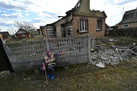 Iäkkäämpi nainen istui tuhoutuneen rakennuksen edustalla Obukhovitšin kylässä torstaina 7. huhtikuuta. 
