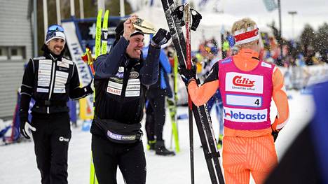 Markus Vuorela, keskellä, suihkuttaa kuohujuomaa kultaisesta pullosta Jänteen ankkuriosuuden hiihtäjän Lauri Lepistön päälle. Taustalla ilakointia seuraa Ristomatti Hakola.