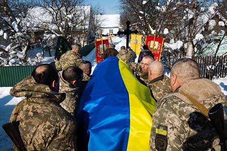Ukrainalaiset sotilaat kantavat sodassa kaatunutta ristisaatossa.