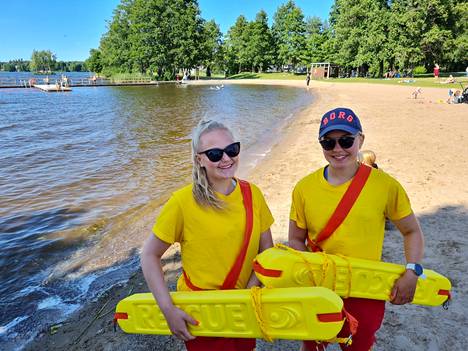 Emma Hakala ja Salla Moisio valvovat uimareita Pororannassa Sastamalan keskustassa. Pelastuspatukka on hätätilanteita varten.