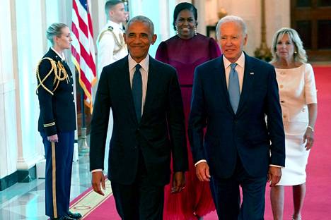 Tilaisuutta Valkoisessa talossa isännöi istuva presidentti Joe Biden (oikealla), joka oli aiemmin Barack Obaman varapresidentti. ”Tervetuloa kotiin, Obamat”, Biden sanoi entiselle työtoverilleen ja tämän puolisolle paljastustilaisuudessa.