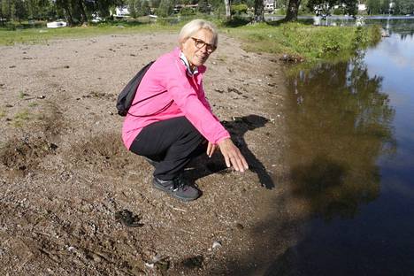 Terttu Nordström näytti maanantaina, että koko Ryydynpohjan uimaranta on ulostesotkussa myös veden alla. Tummia kasoja on myös taustan nurmikko täynnä.
